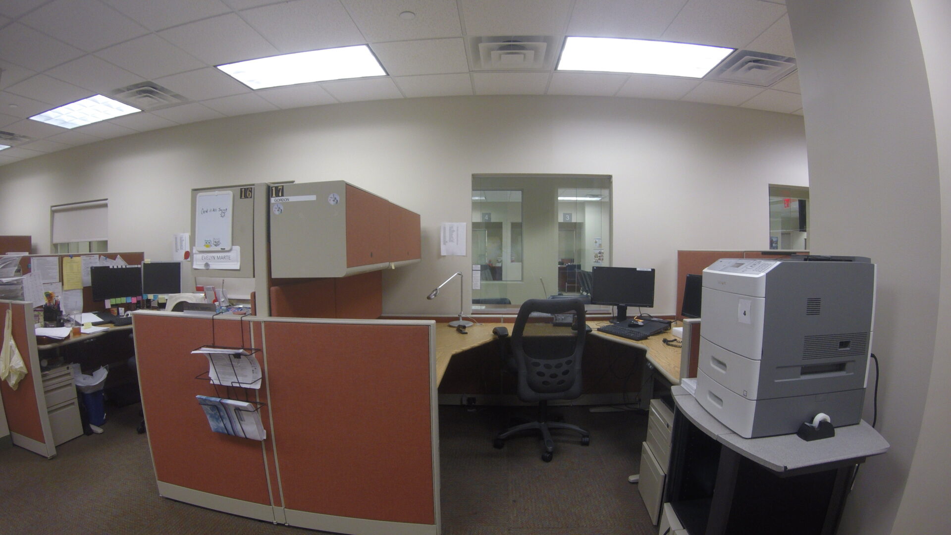 A view of an office cubicle with a desk and chair.