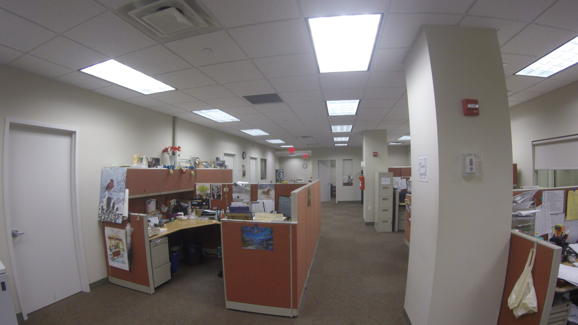 A large office with many cubicles and lights.