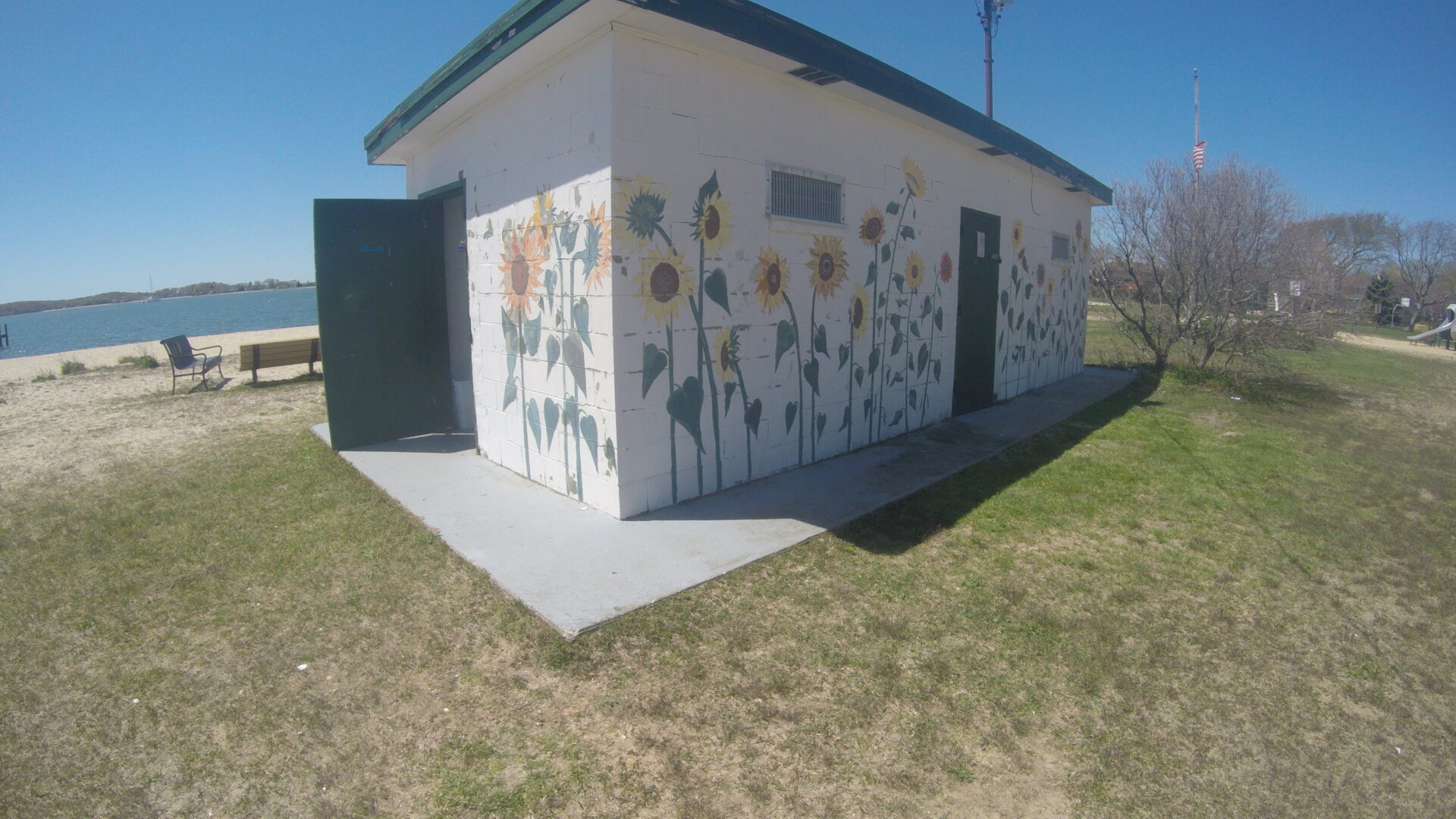 A small white building with flowers painted on it.